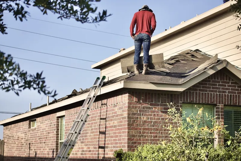 Professional roofer working on a residential roof in Redford